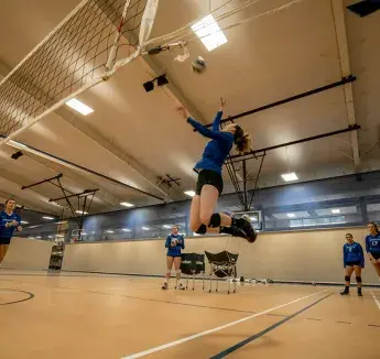 Student spiking a ball during a volleyball game