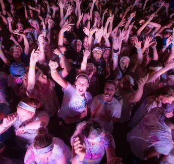 Students shouting and raising their arms in party atmosphere.