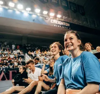 Students laughing and smiling in auditorium audience.
