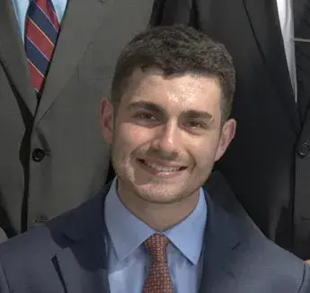 Danny Akkad smiling in suit and tie