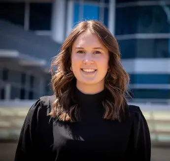 Olivia Nicholson smiling on sunny day on Creighton campus.