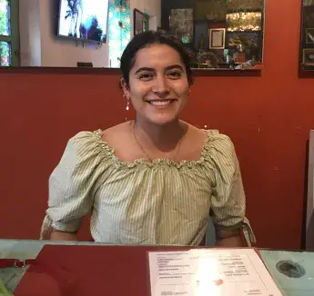 Anna Cloonan smiling while sitting at table.