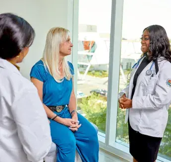 Two caregivers consulting with standardized patient. 