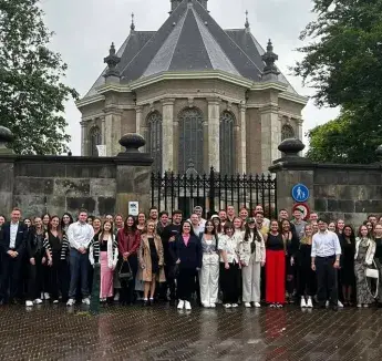 Students posing in group picture on rainy day.