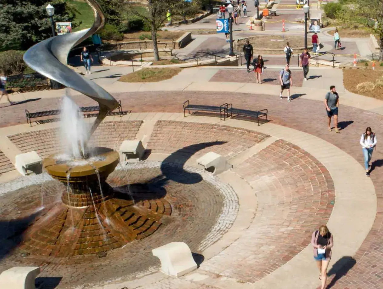 Creighton students walking by fountain on campus