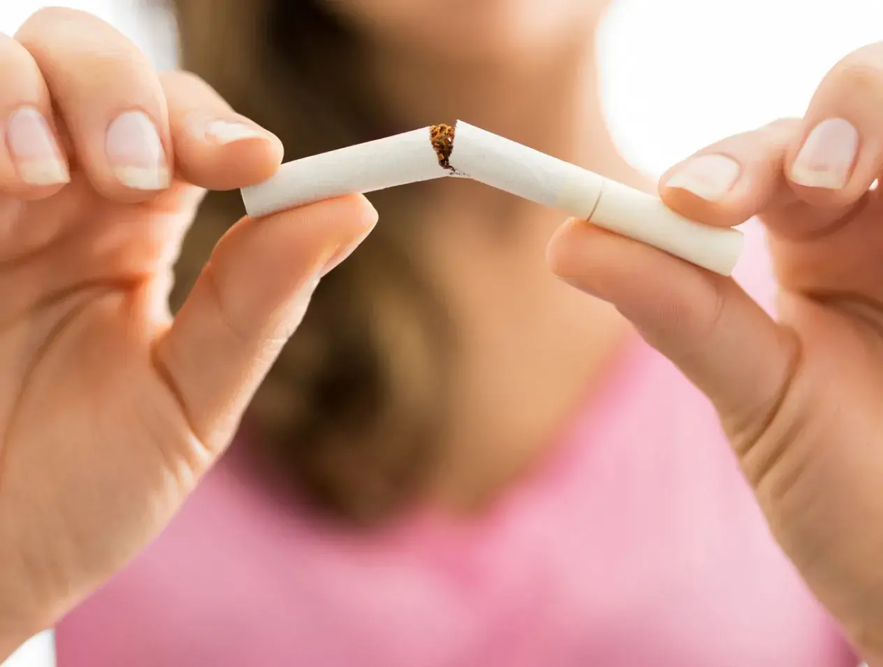 Woman breaking a cigarette in half