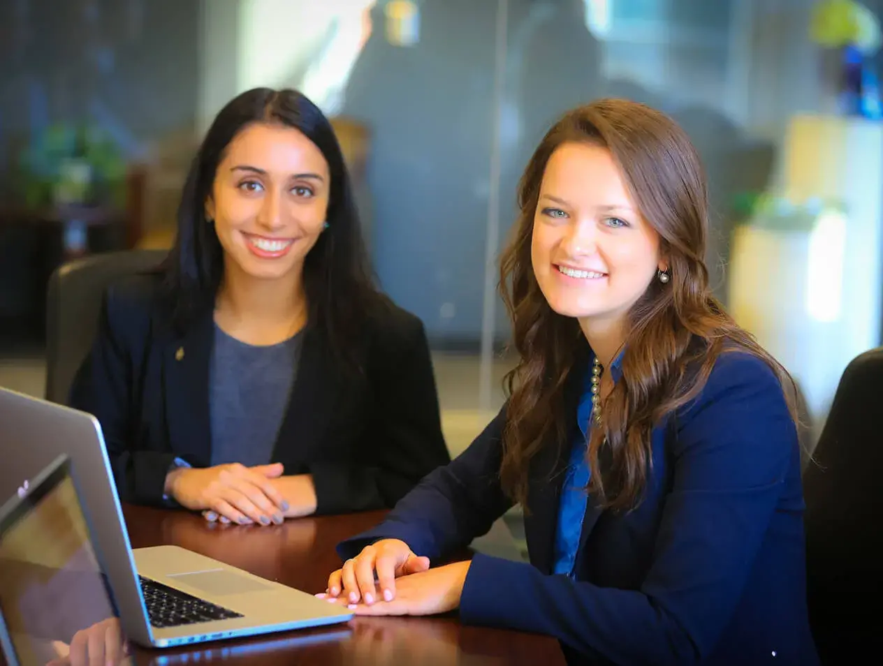 Two marketing students sitting at a table with a laptop