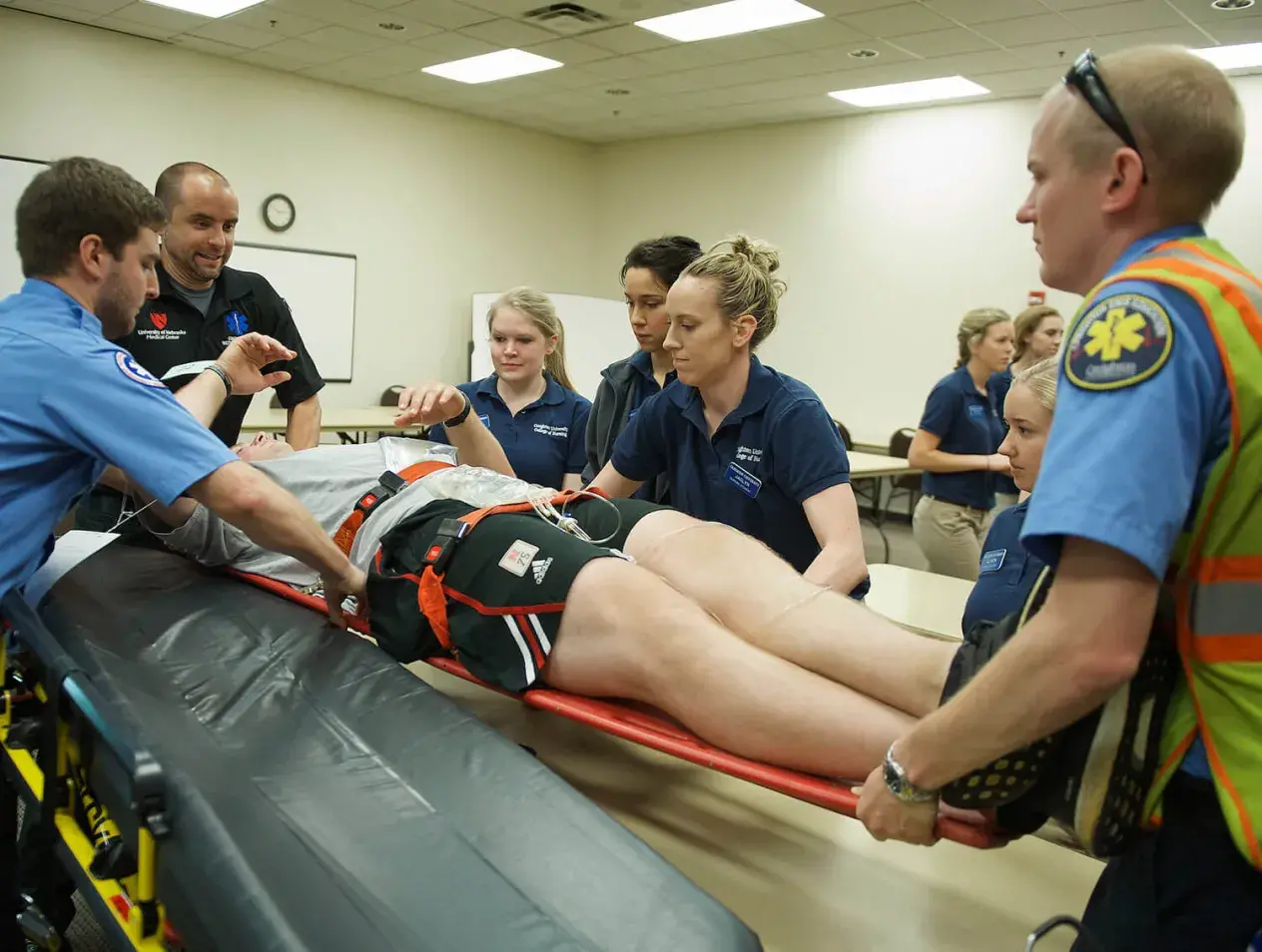 EMS students learning how to move a patient with a stretcher