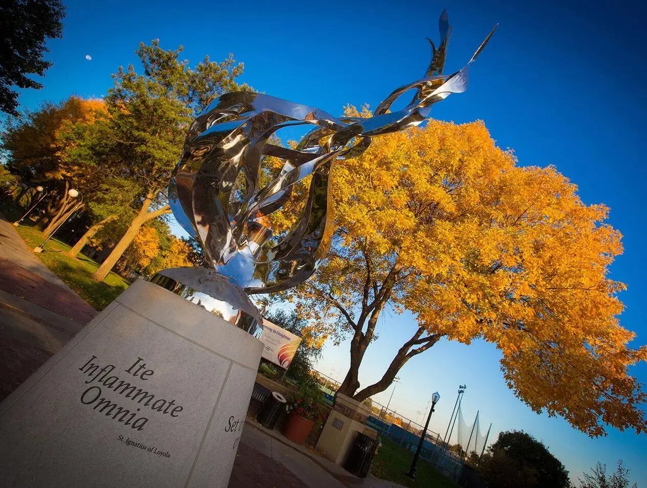 The Flame sculpture with trees changing color during fall in the background