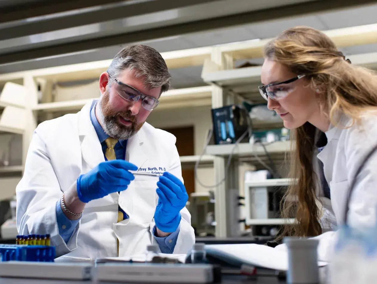 E. Jeffrey North examining a lab specimen with a student