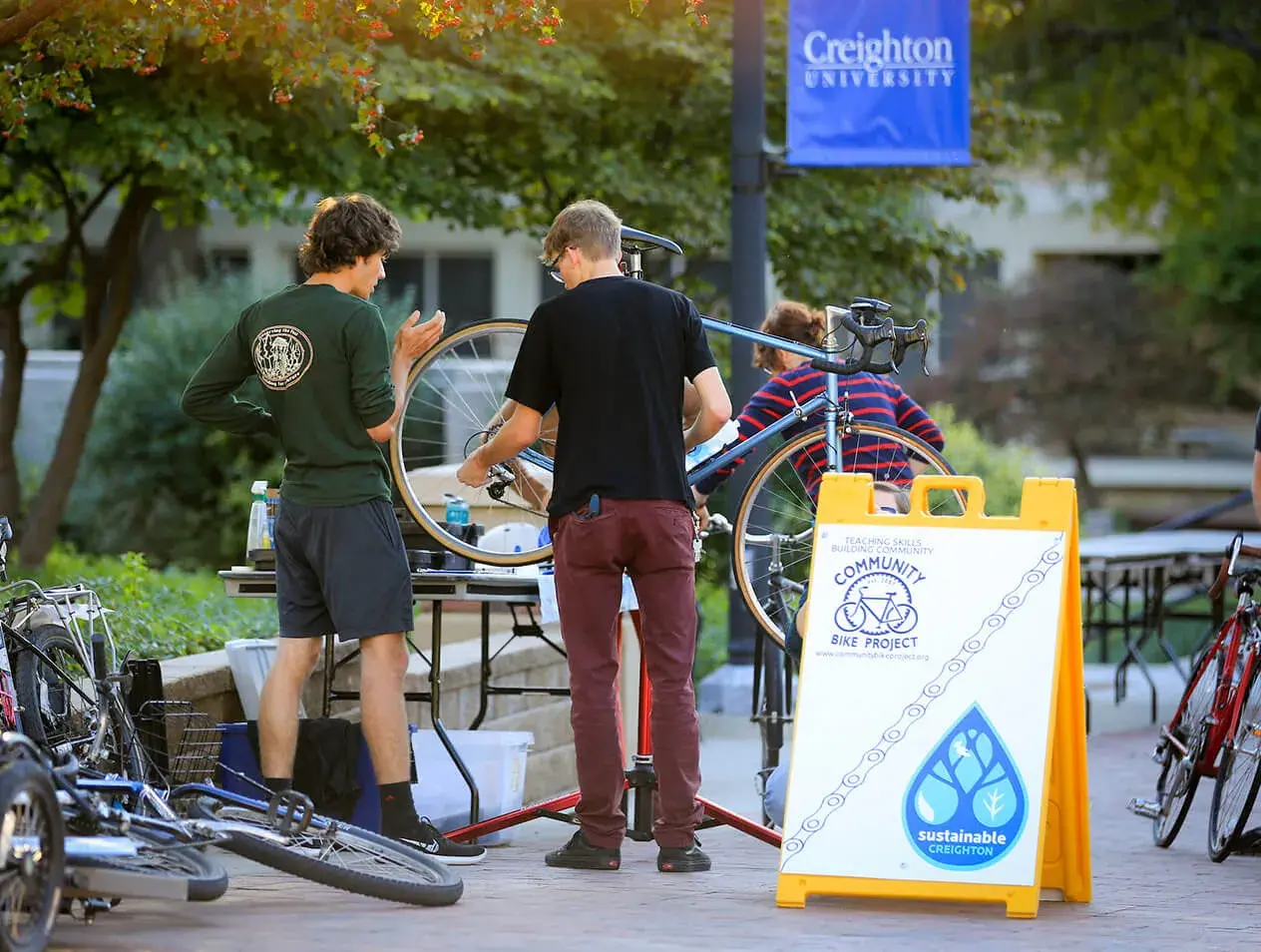 Students repair a bicycle during a Creighton Bike Project event