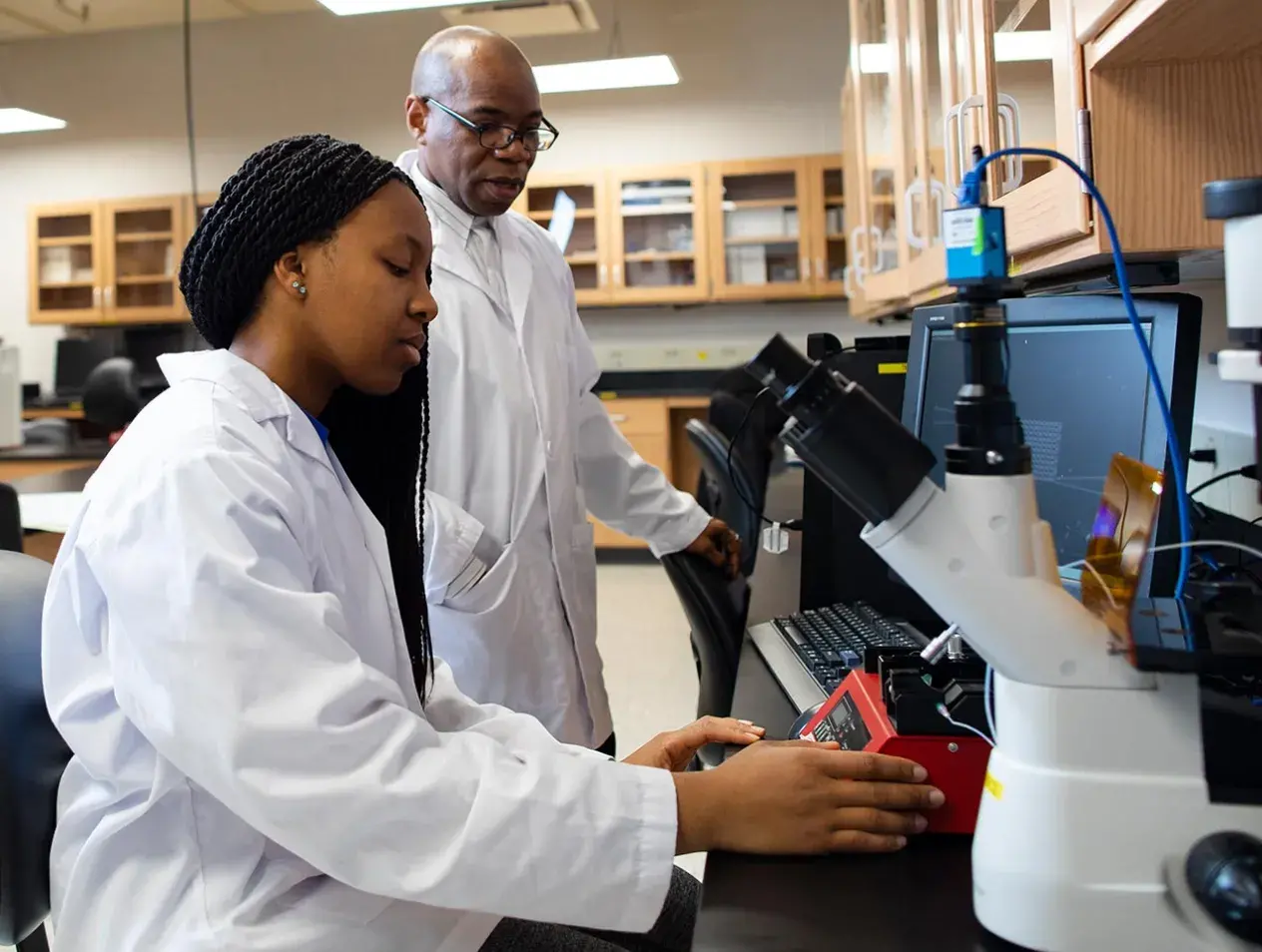 Dr. Ekpenyong in lab with student