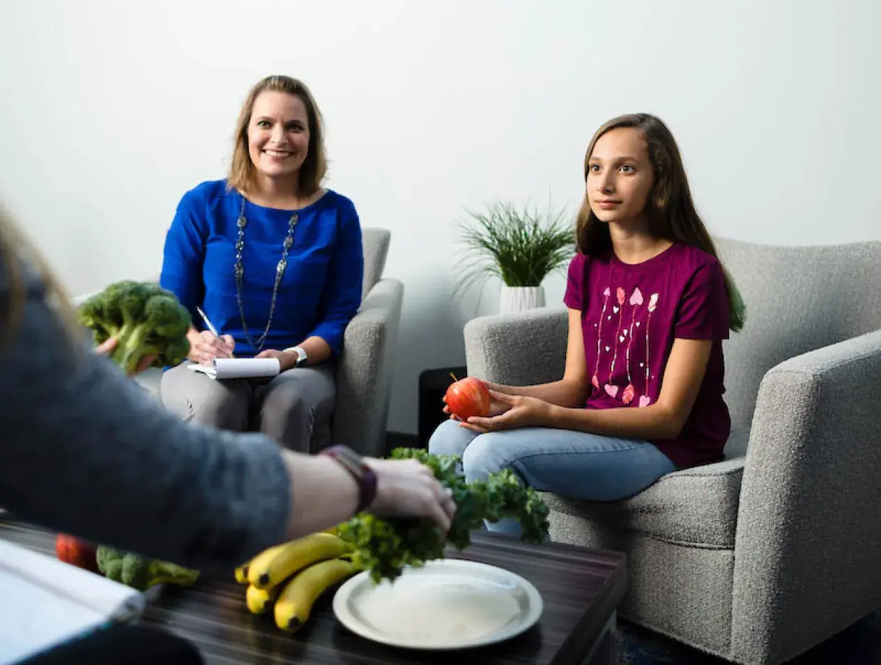 Adult and child talking about dietary wellness with fruits and vegetables on display.