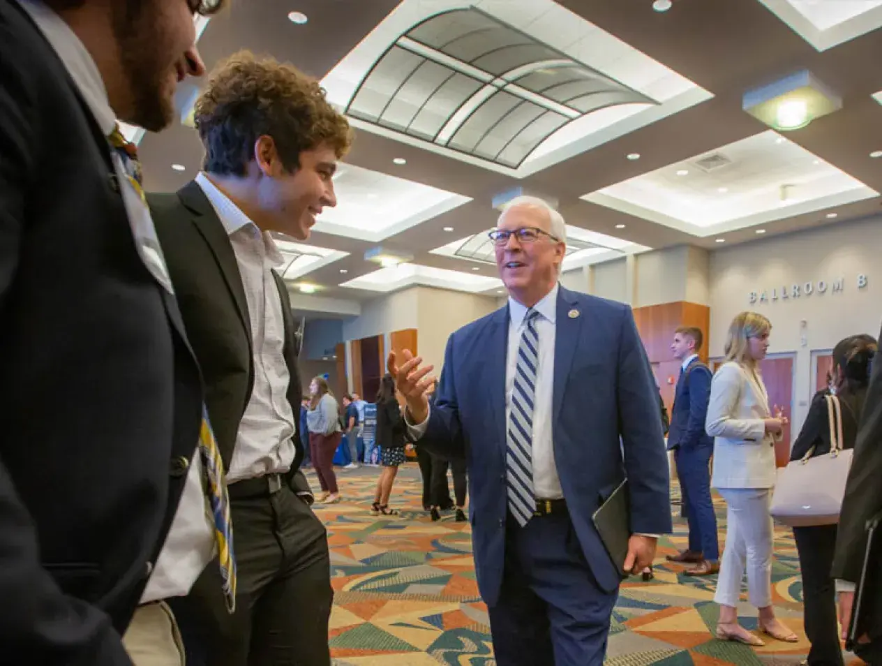 Anthony Hendrickson talking with students at college event.