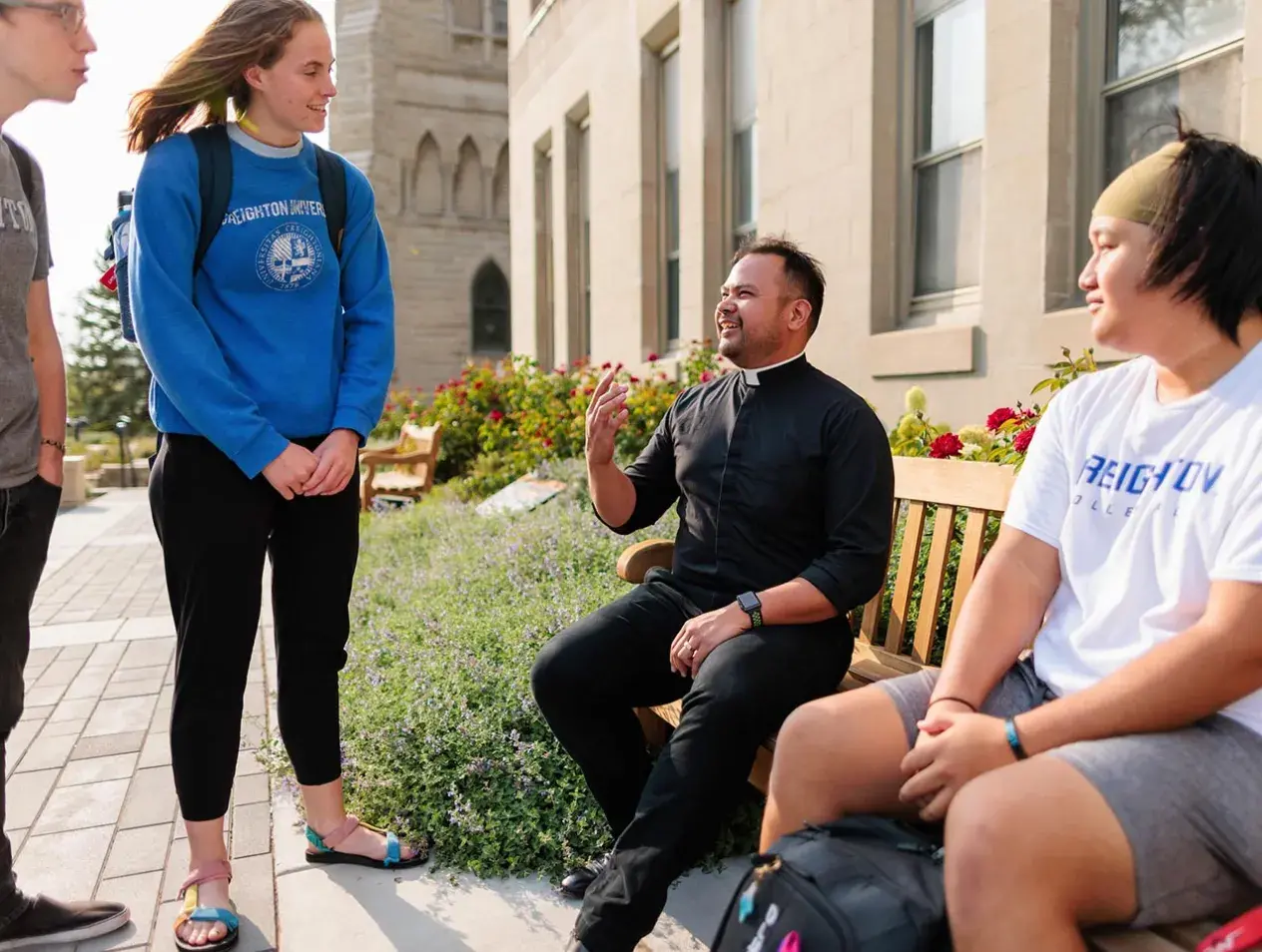 Jesuit speaking with students