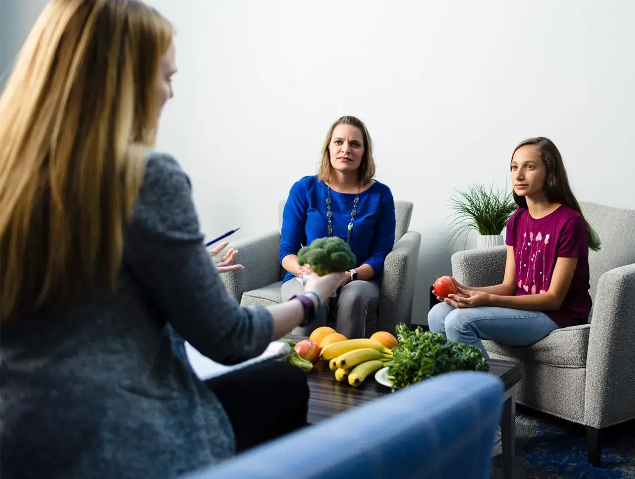 Health Professionall discussing foods with woman and girl