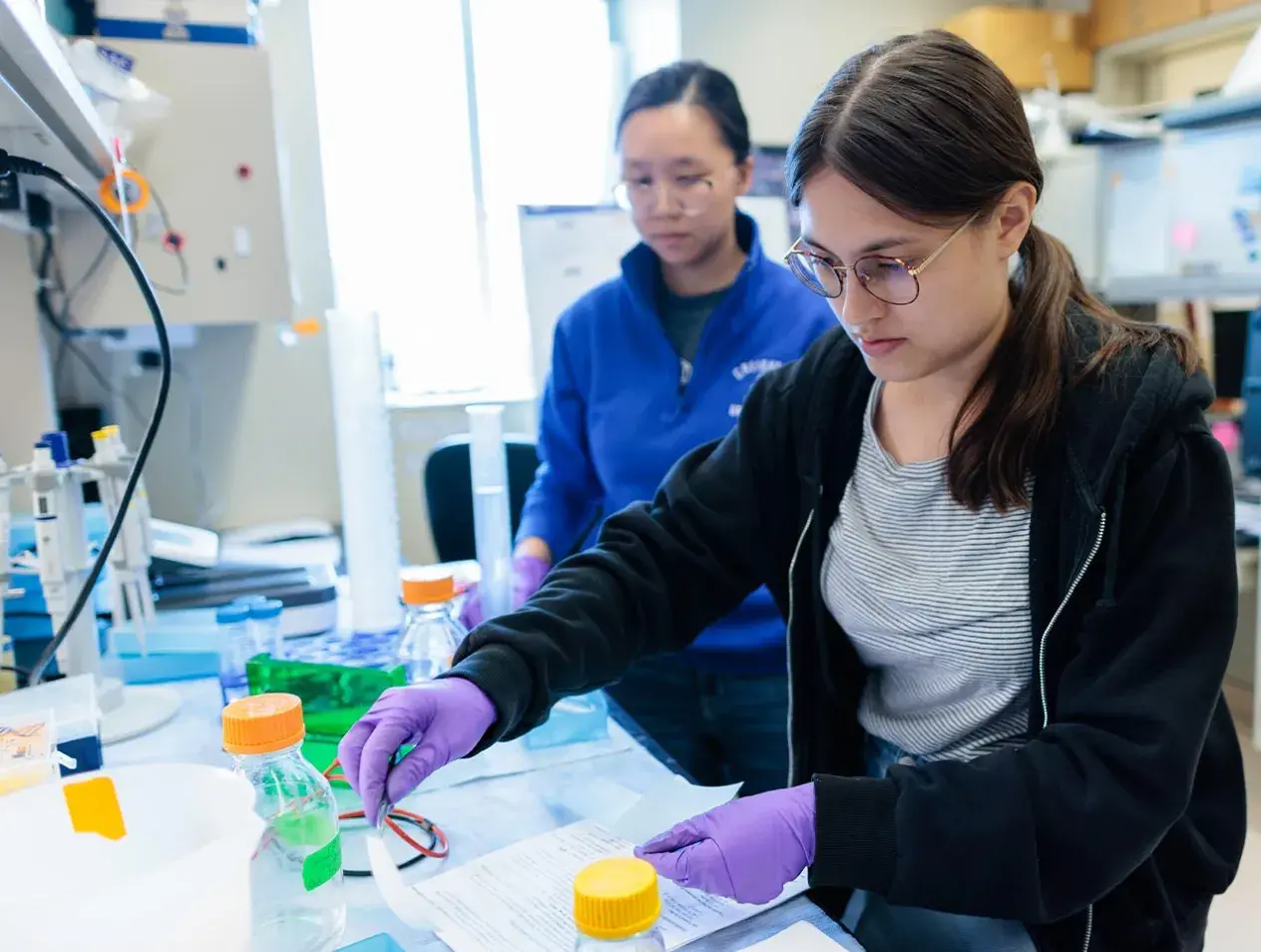 Two female students in Microbiology and Immunology research lab