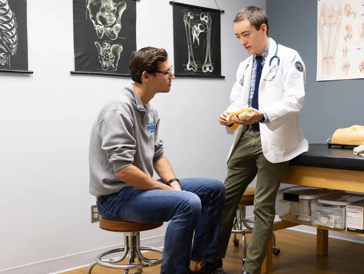 Male doctor discussing with male patient in exam room