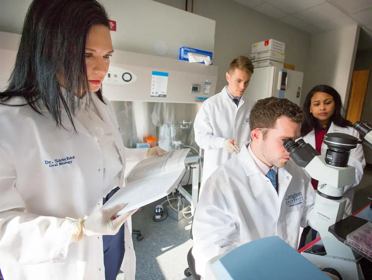Oral biologists working with microsope in lab