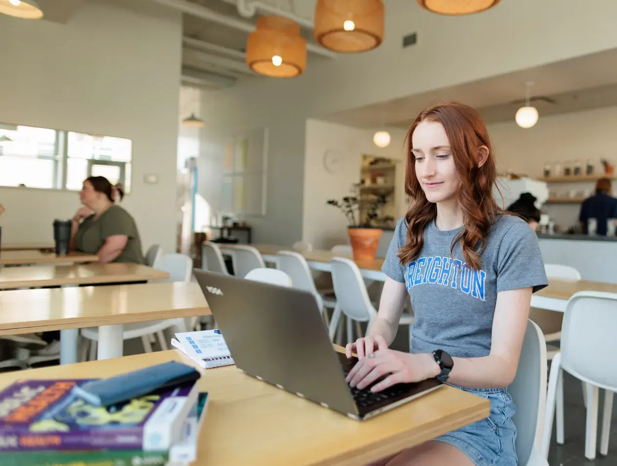 Student working on laptop in coffee shop