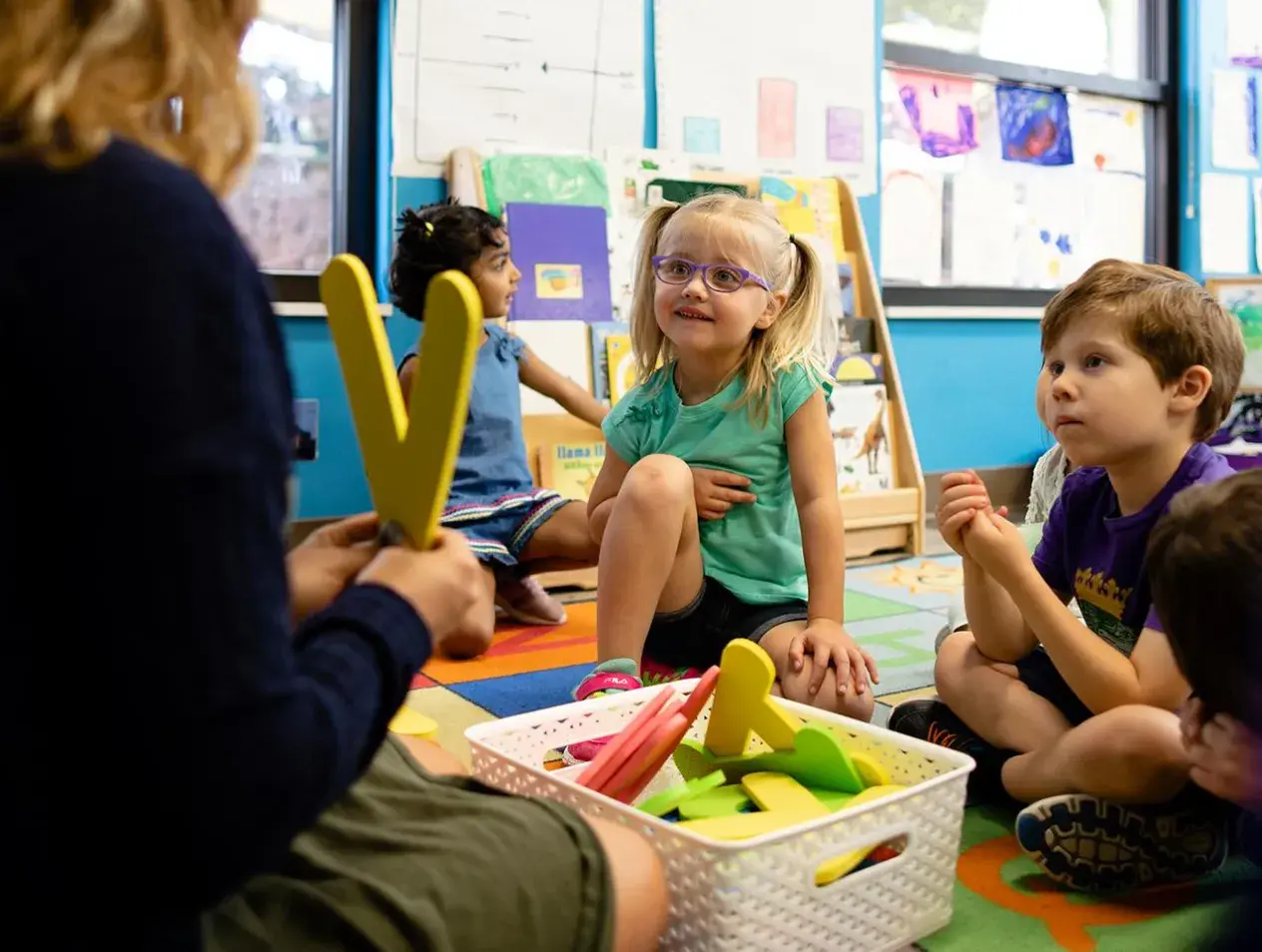 Children learning with teacher in the classroom.