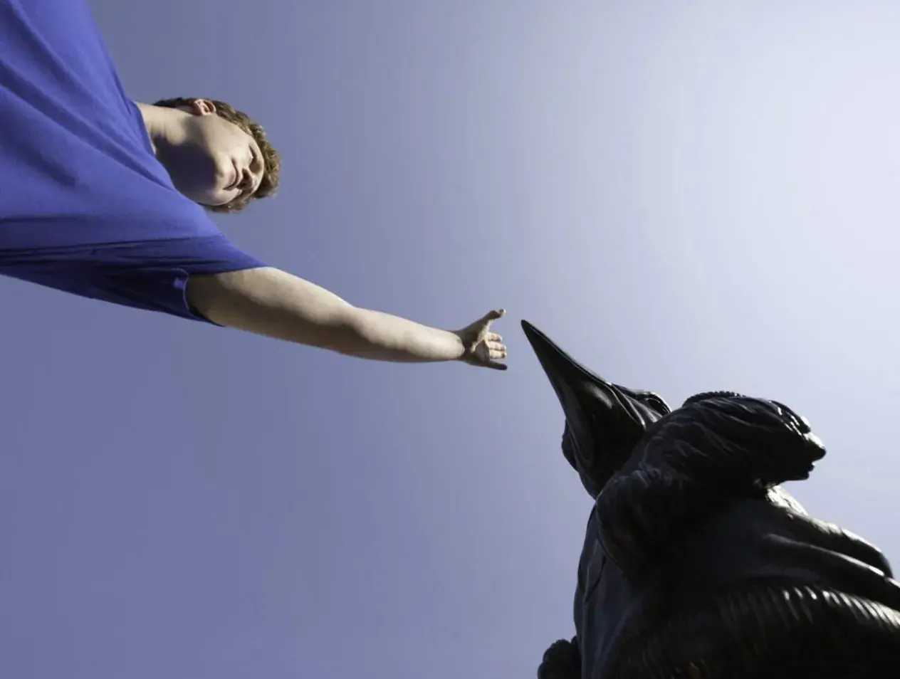 Student touching the bluejay statue
