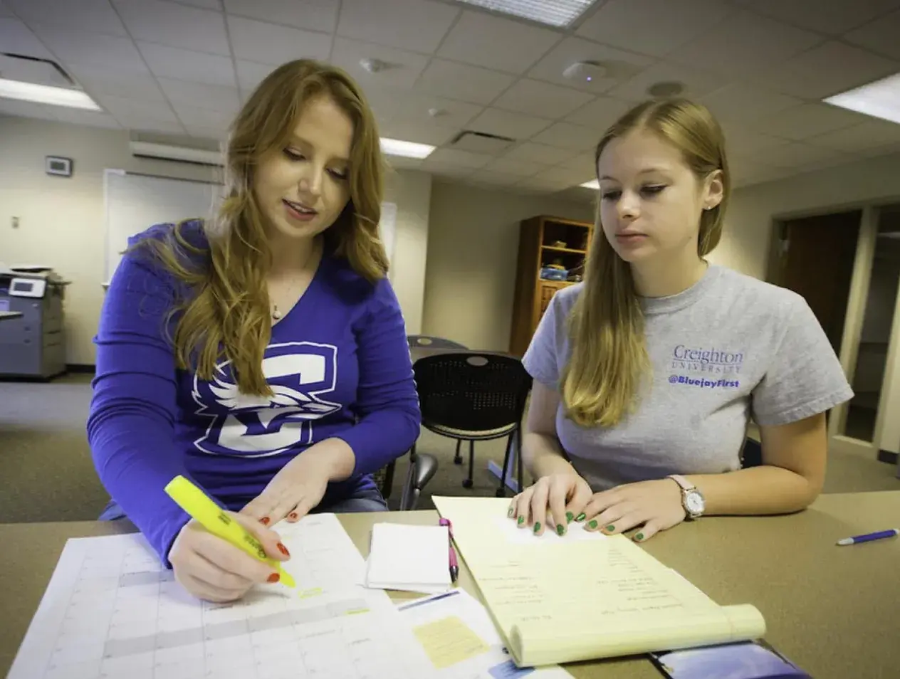 TRiO students at table working on papers using big yellow marker