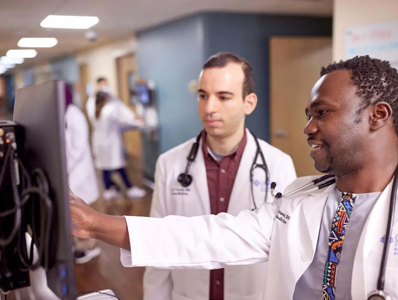 Residents studying data in hospital hallway