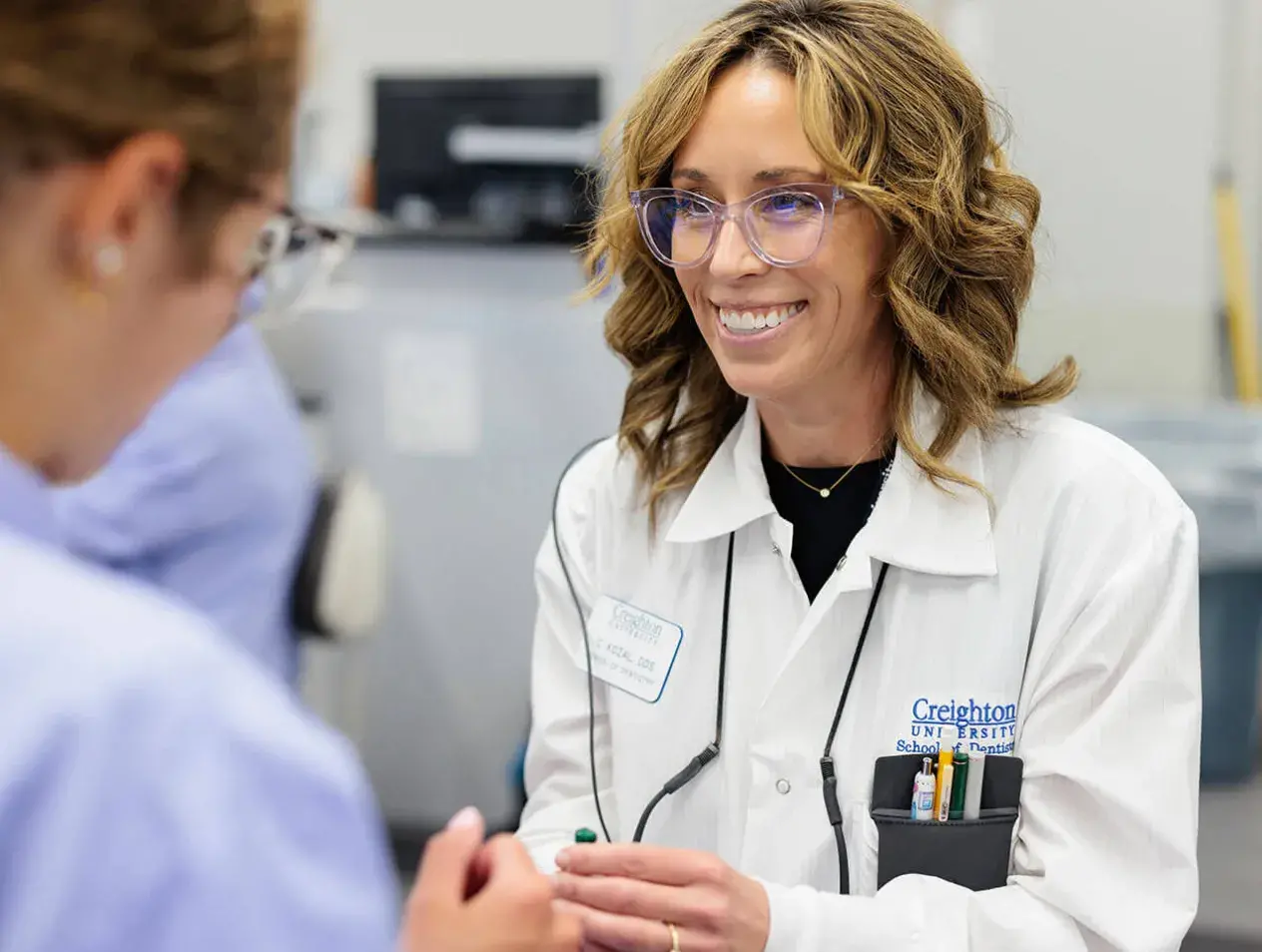 Creighton dentist in white coat smiling
