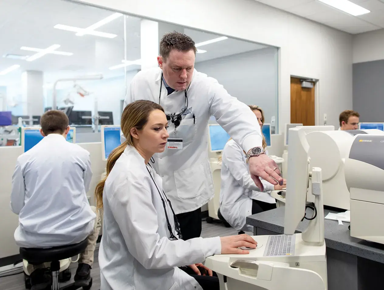 Dental student and professor on computer