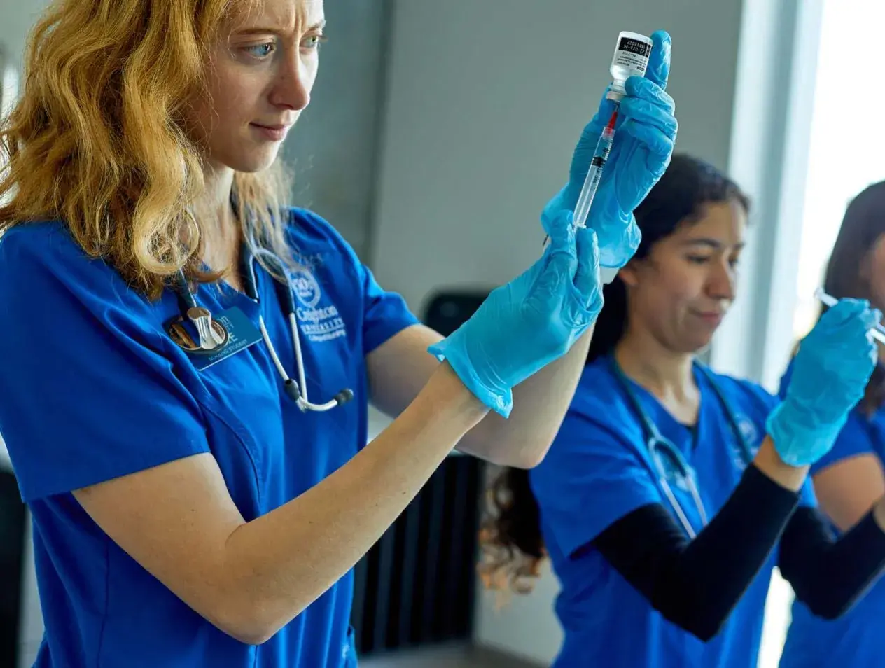 Nurses practicing on syringes