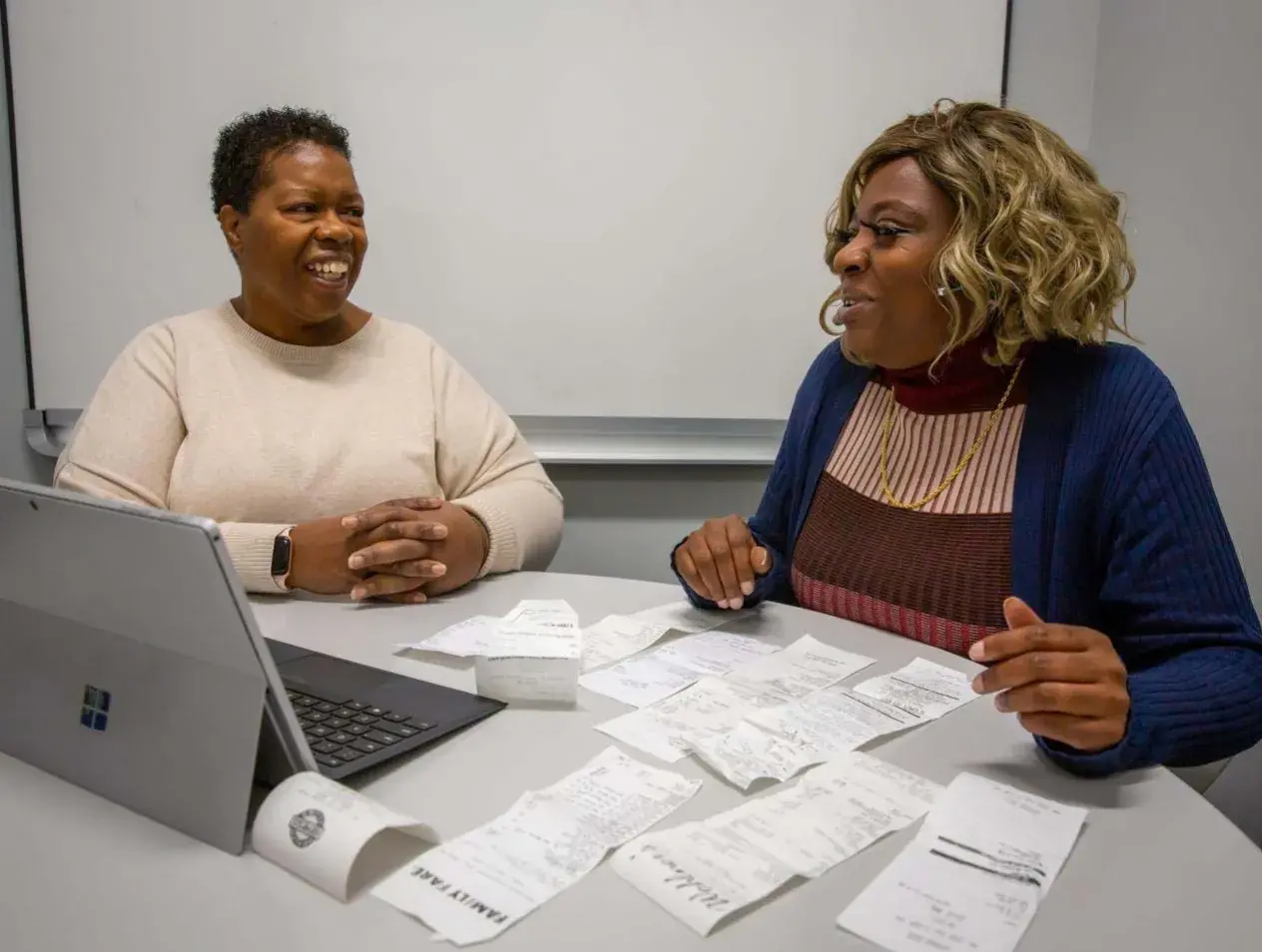Two women working and smiling in Financial Hope office.