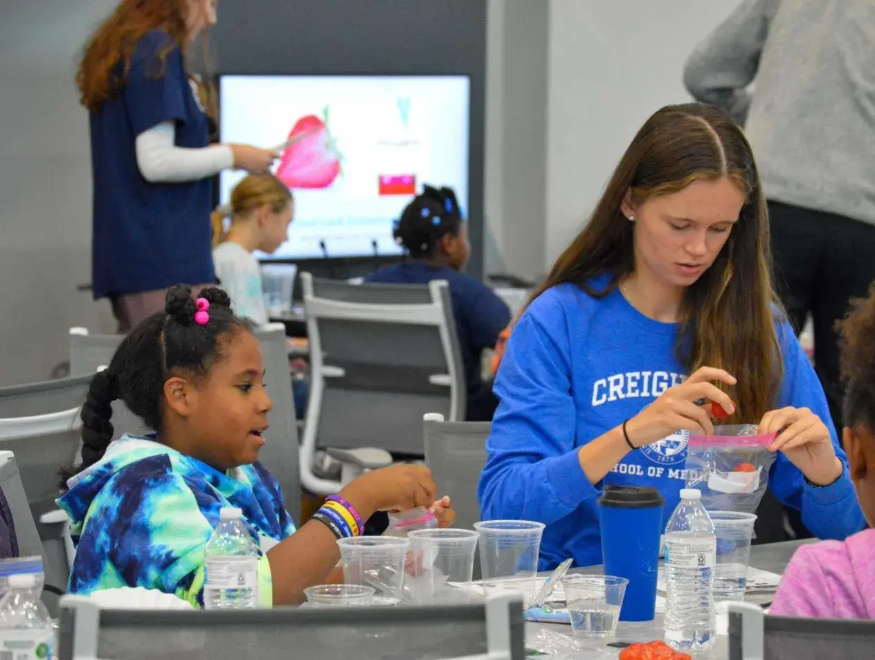 elementary student and medical student doing an experiment