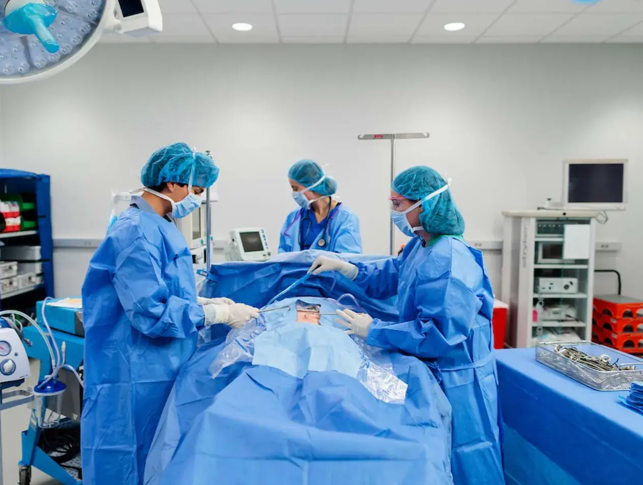Surgery room with surgeons performing operation.