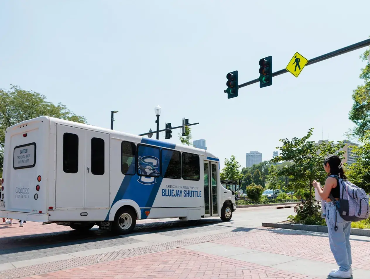 Female student waiting outside a Bluejay shuttle.