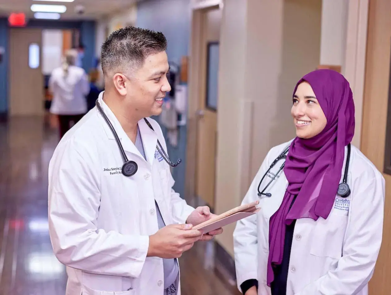 Residents conversing in hospital hallway.