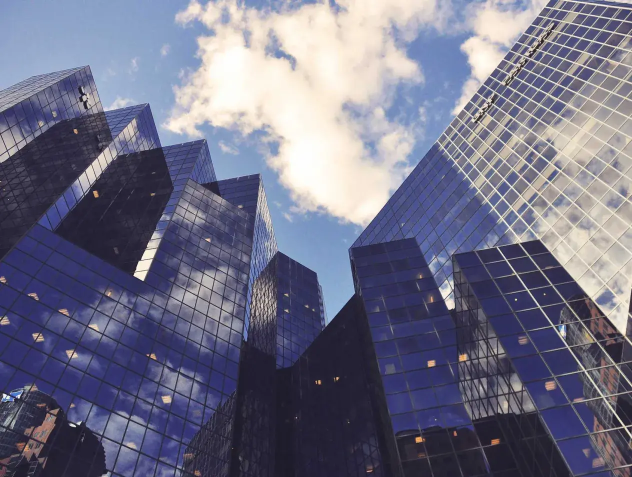 Street view looking upward at two skyscrapers made of glass