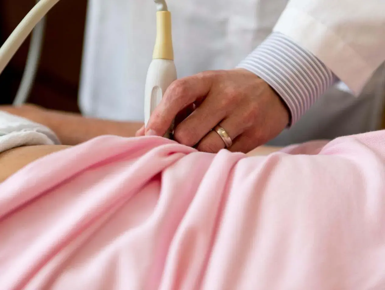 Examining pregnancy in exam room.