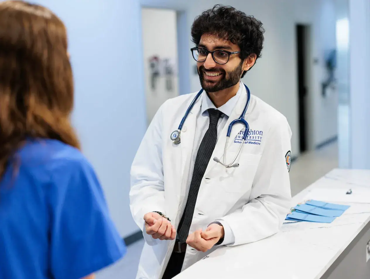 Doctor talking with colleague in hospital setting.