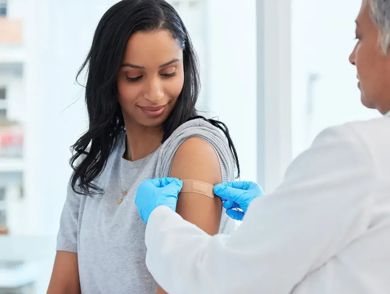 Nurse providing immunization shot to patient.