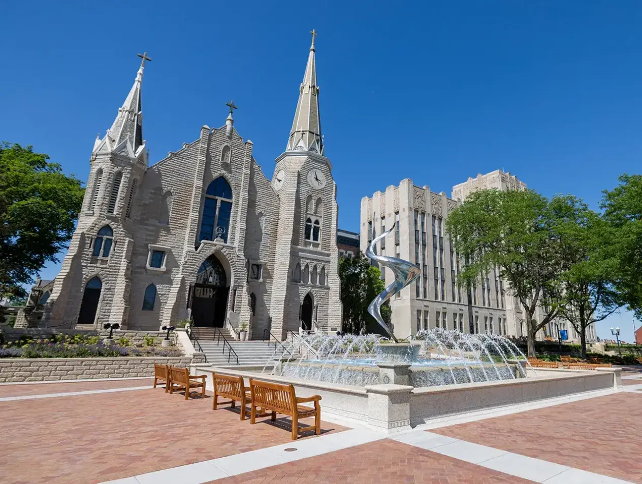 St. John's church on campus with flame fountain in the foreground.
