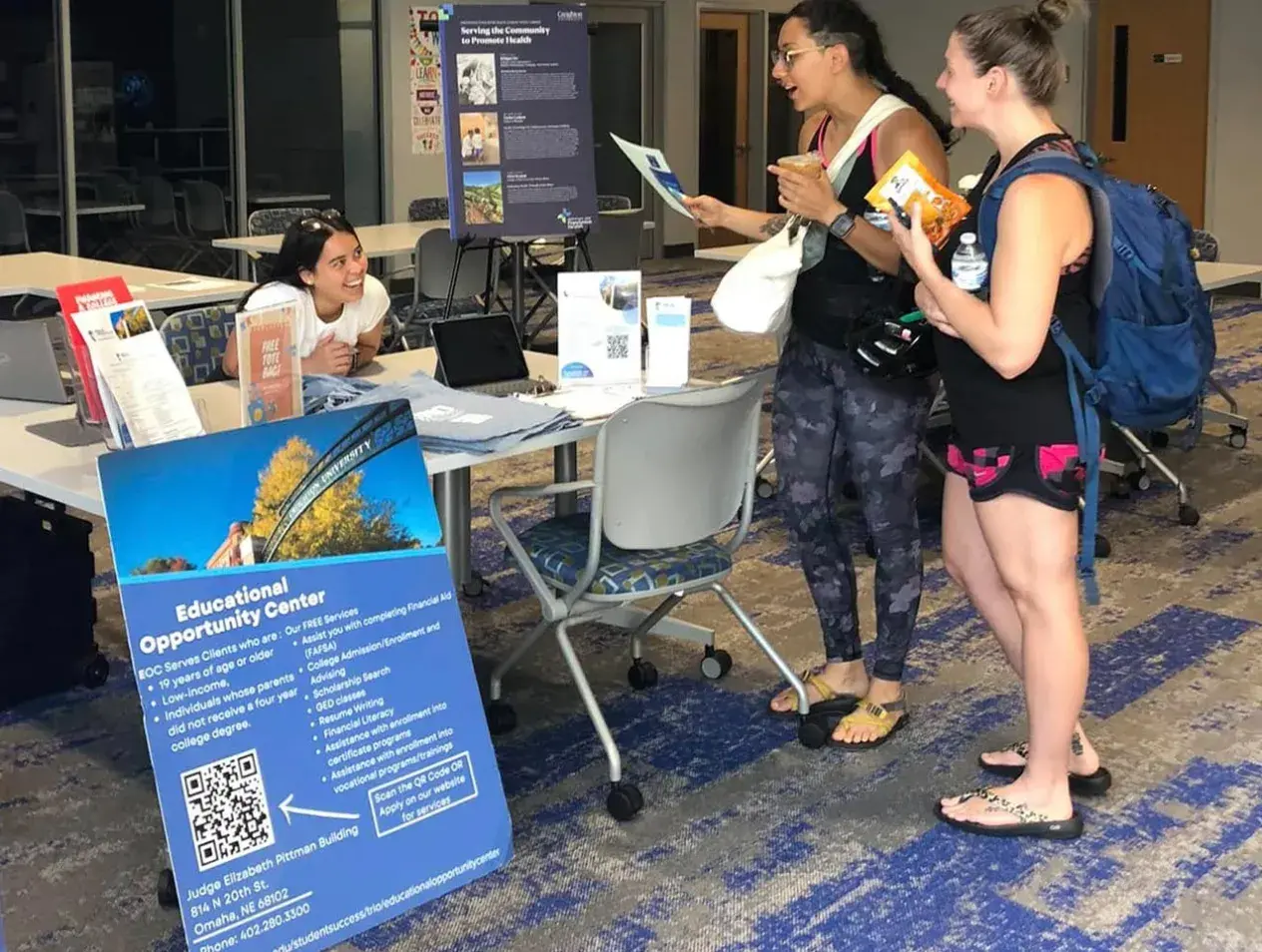 Three female students at an event table