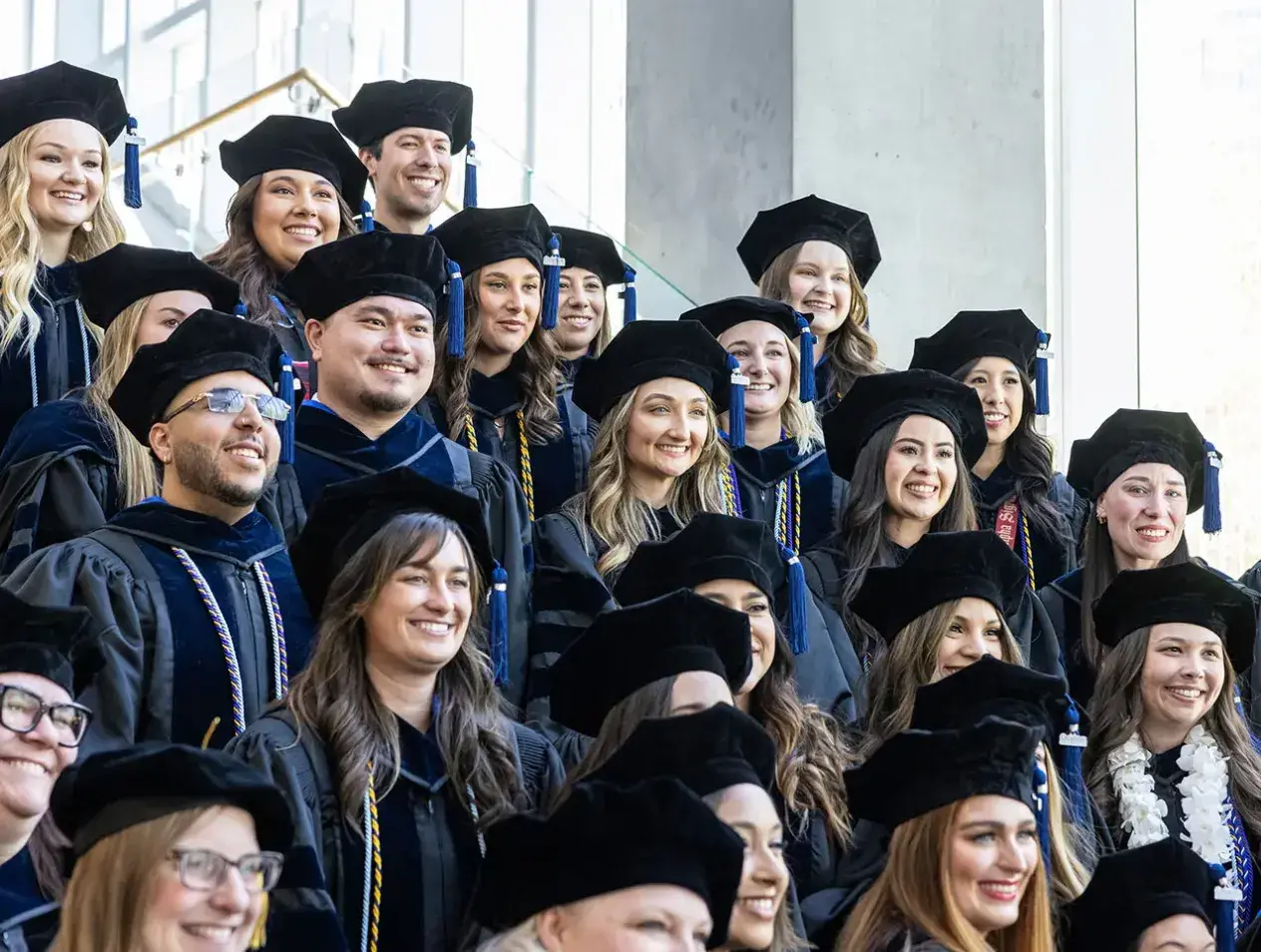 Graduates in regalia on steps in Heider College of Business