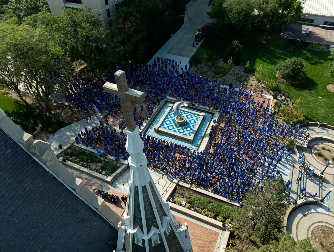 Drone photograph from above of students gathered around fountain.