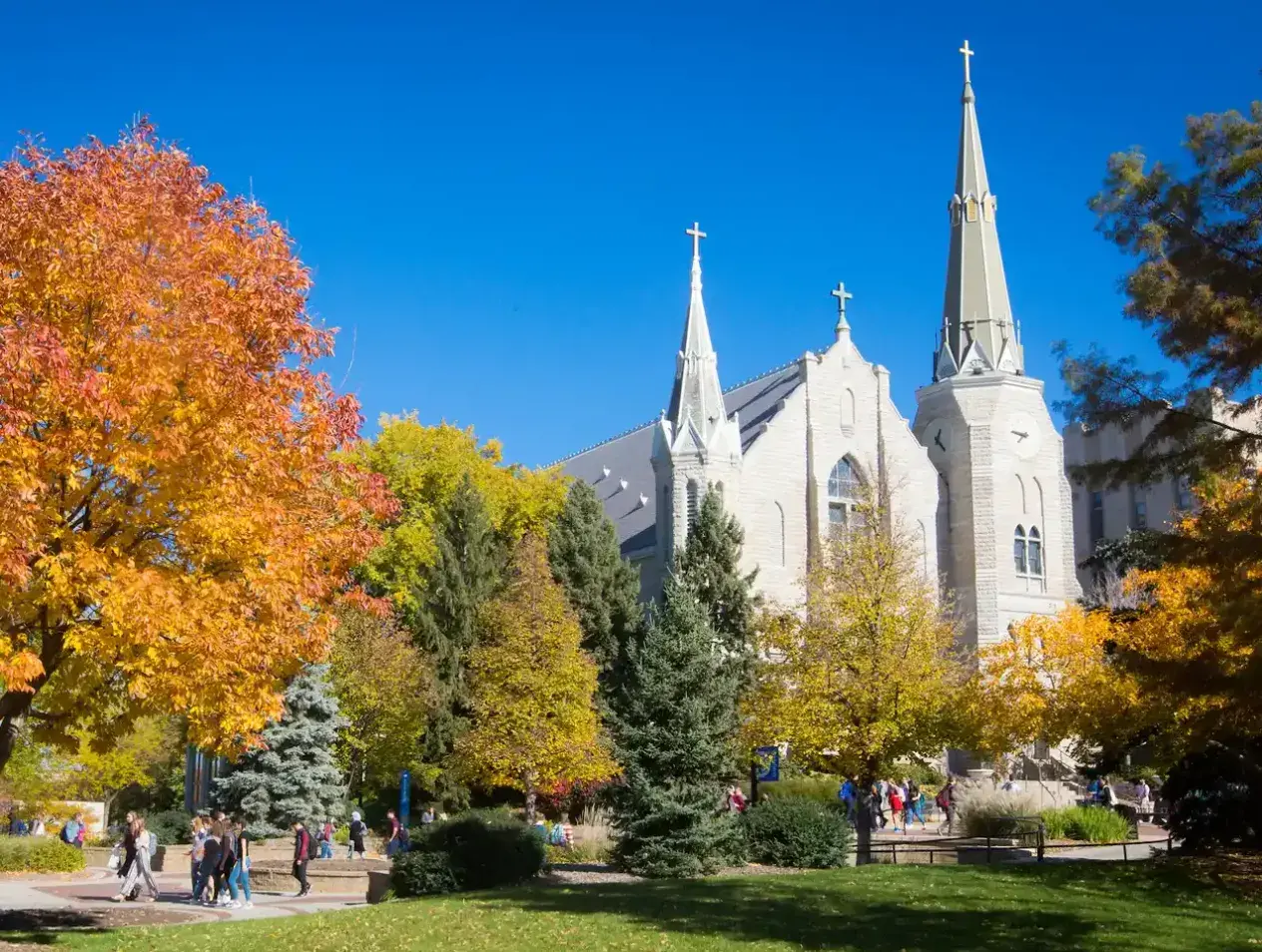Families walking into church on fall day.