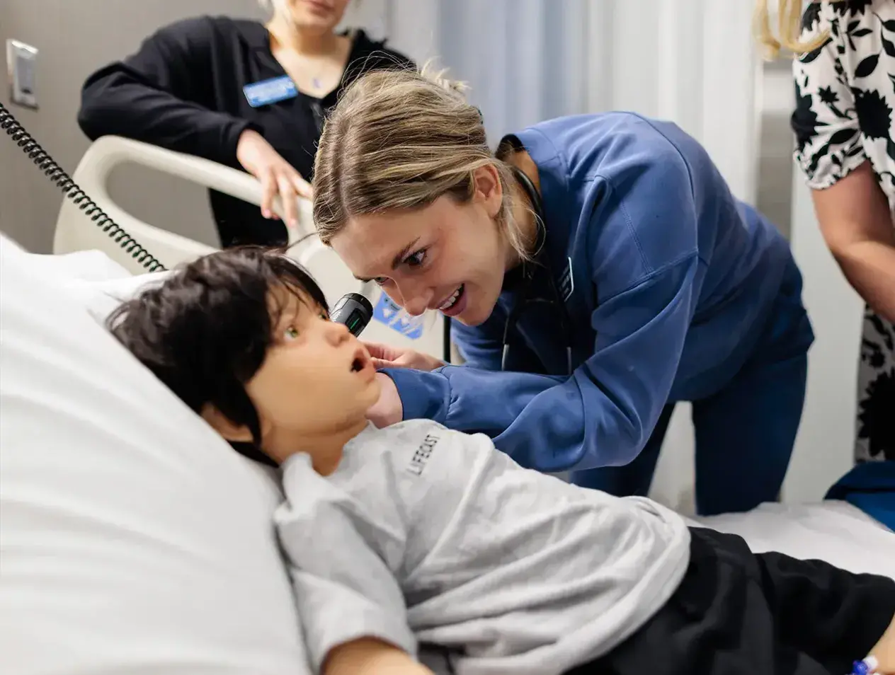 Nursing student examining child patient.