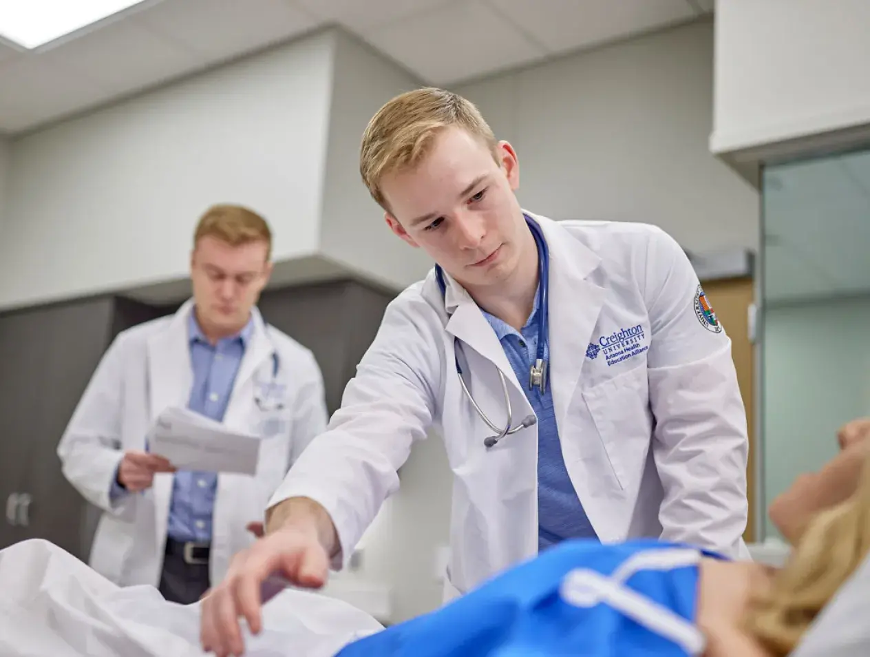 two professional students in sim lab
