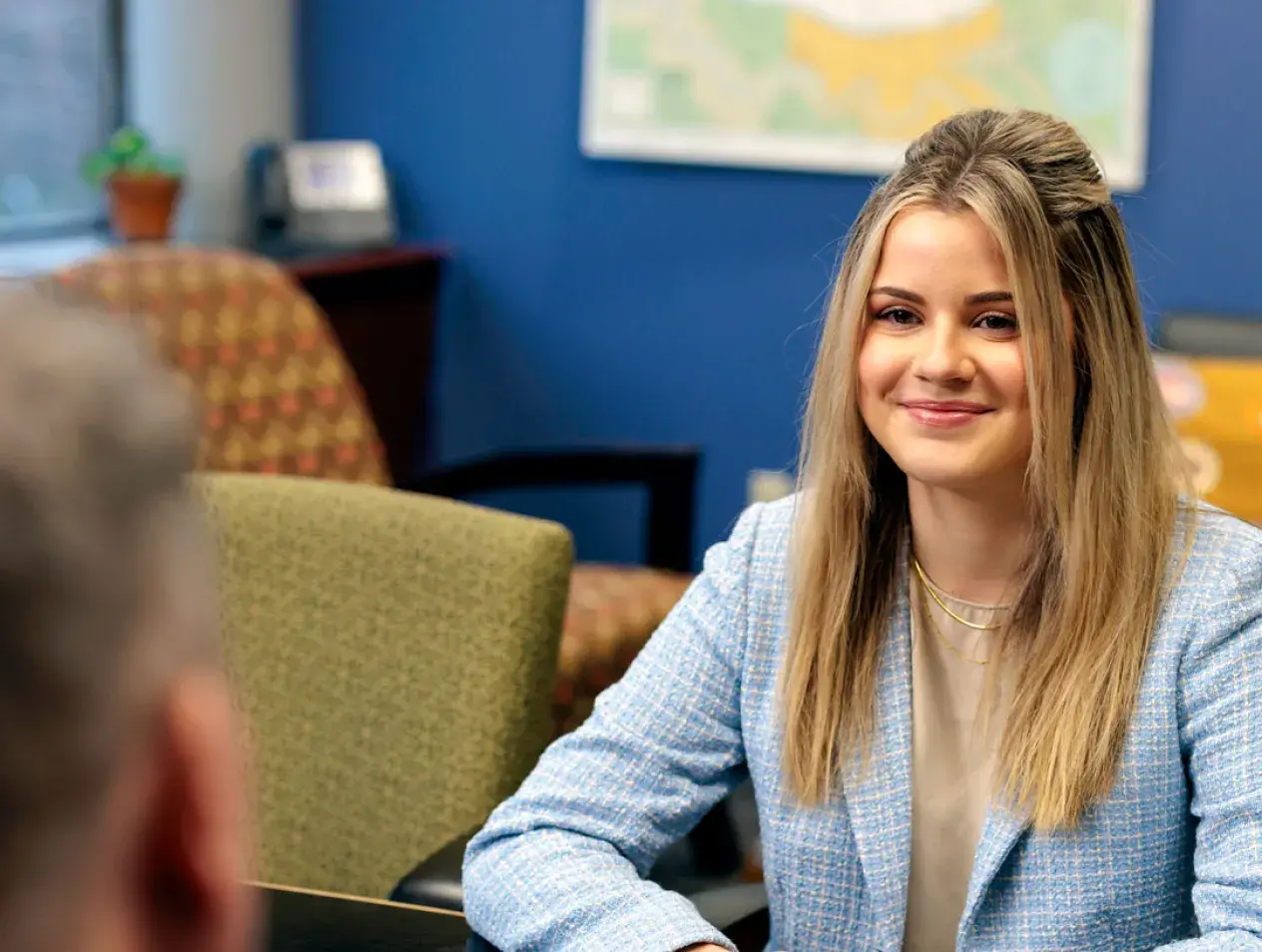 Female student at desk listening to a question