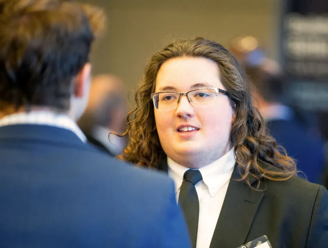 Student in suit talking at an event