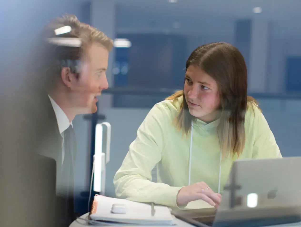 Two students talking in a huddle room